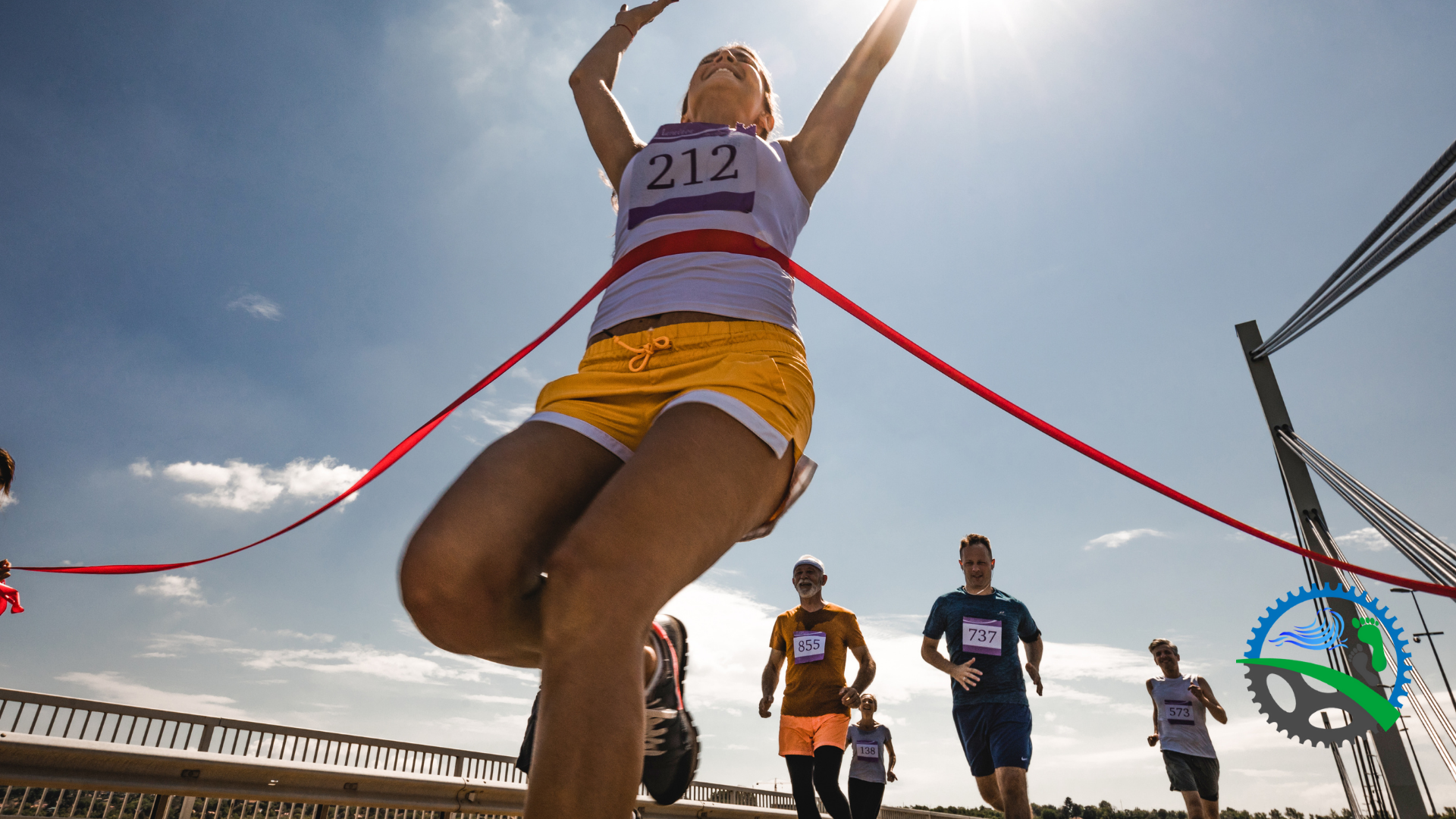 Marathon runner crossing finish line with arms raised in triumph